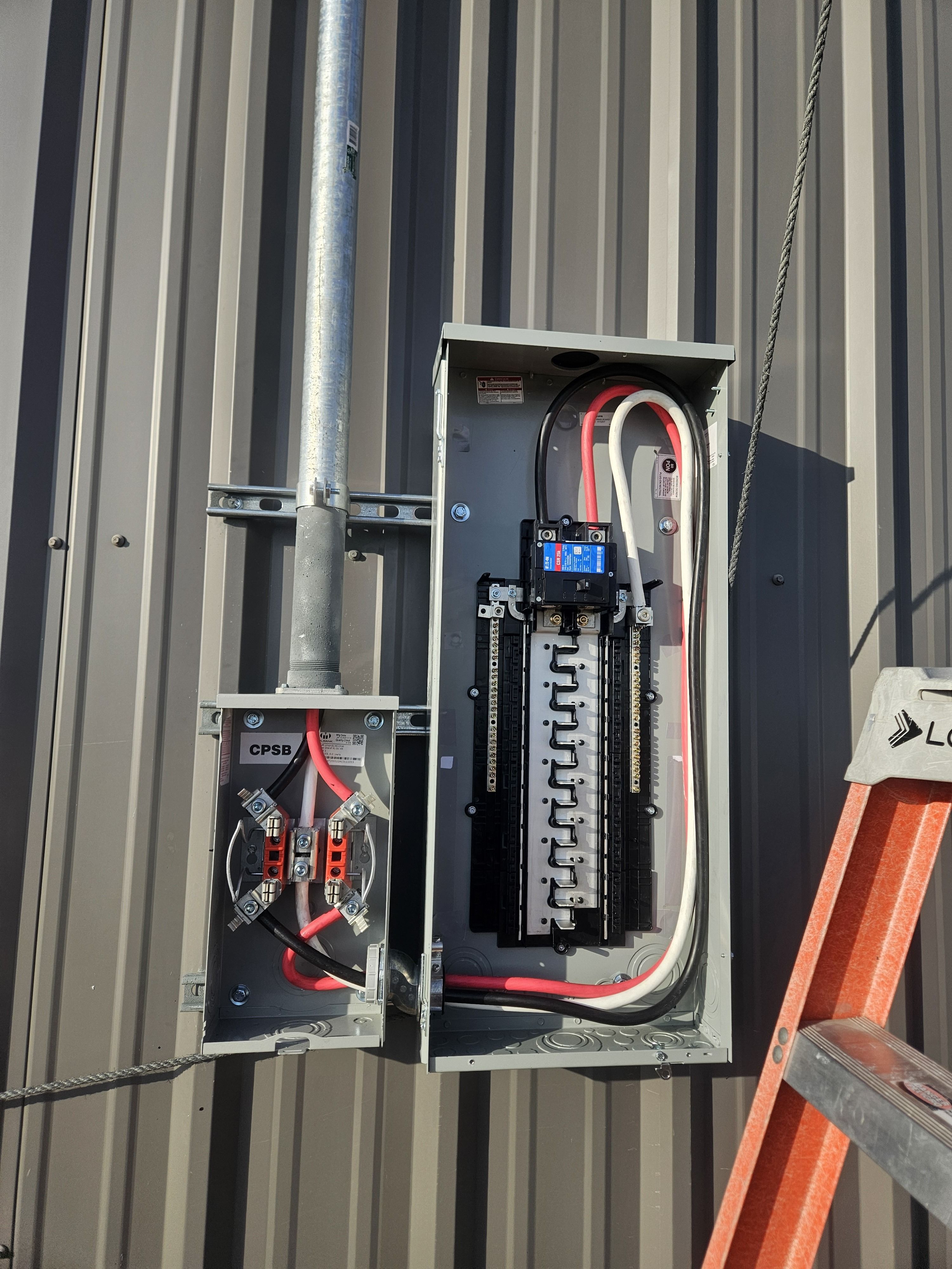 Open electrical panel with main breaker, tidy conductor routing, and a wireway below